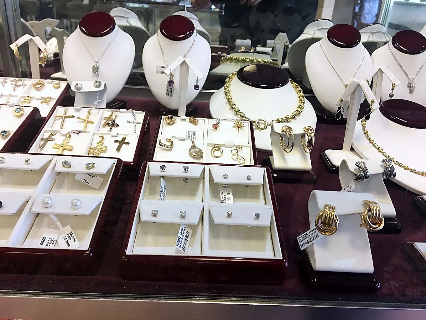 Gold crosses, earrings and pearl studs in the case