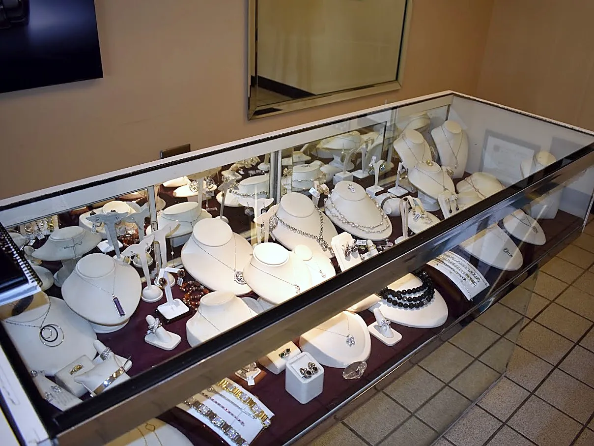 The long case by the wall, necklaces on white busts
