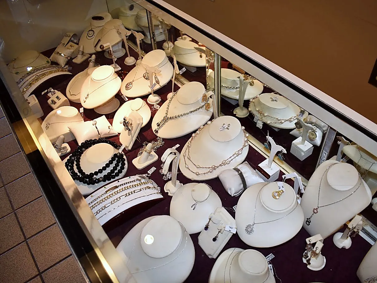 Necklaces and pendants on white busts, seen from above the case